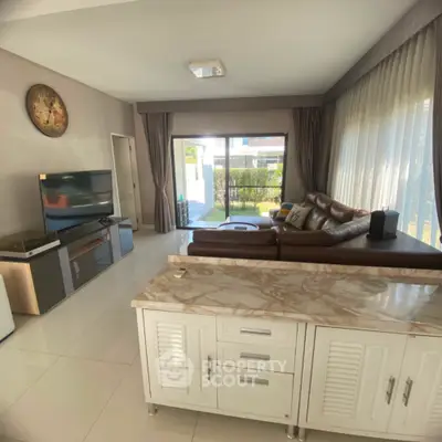 Spacious living room with modern decor and large windows offering garden view