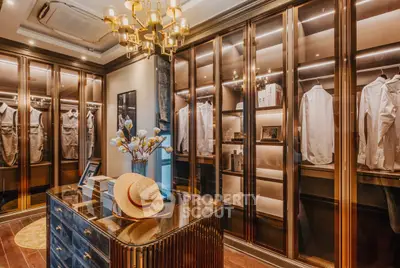 Luxurious walk-in closet with elegant lighting and ample storage space.