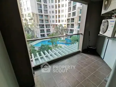 Spacious balcony with pool view in modern apartment complex