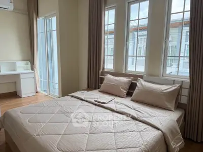 Spacious bedroom with large windows and natural light in modern apartment