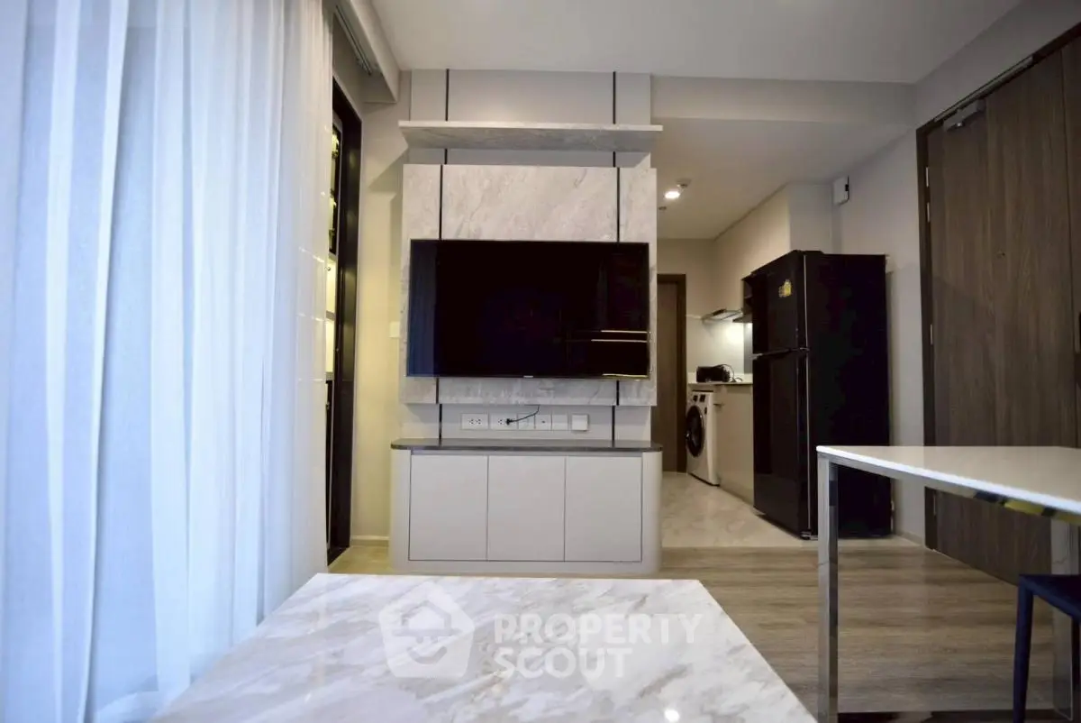 Modern living room with sleek TV setup and open kitchen layout