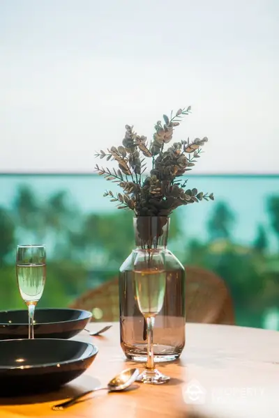 Elegant dining setup with ocean view, featuring stylish tableware and decor.