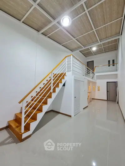 Spacious modern interior with wooden staircase and high ceiling