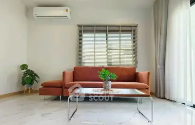 Modern living room with stylish sofa, air conditioning, and large window for natural light.