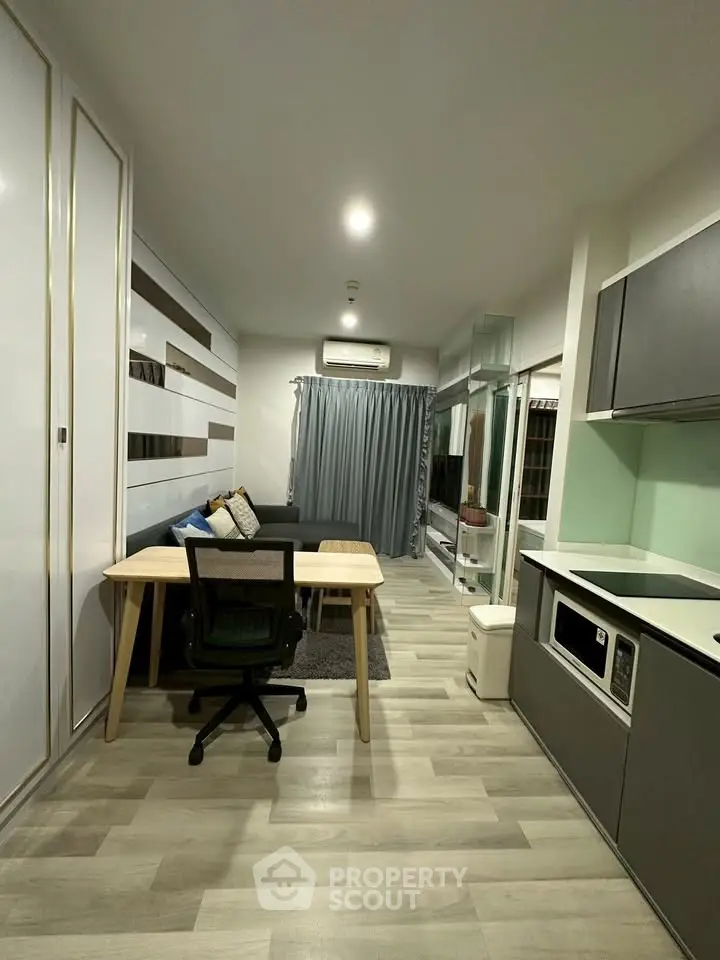 Modern studio apartment with sleek kitchen and cozy living area, perfect for urban living.