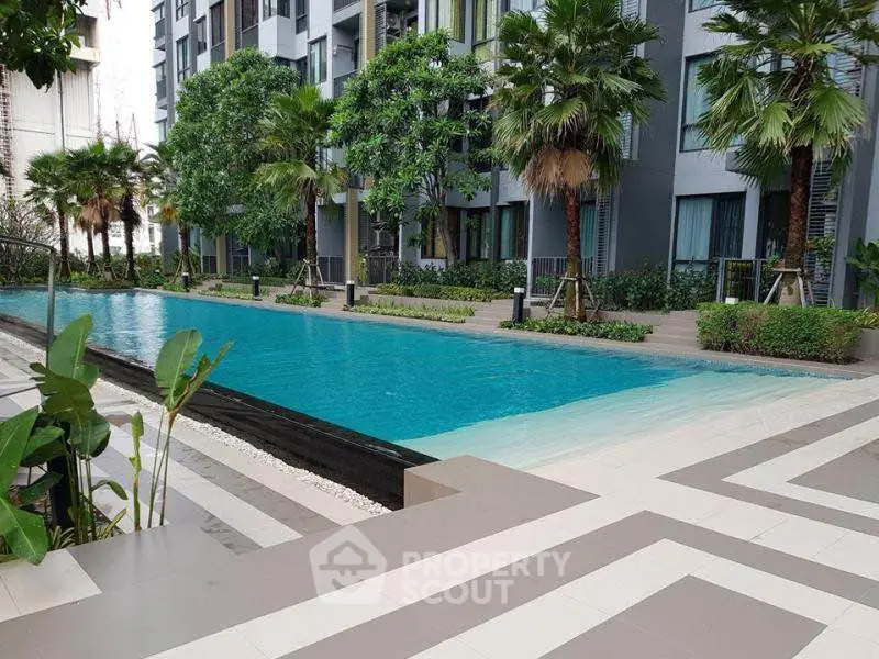 Luxurious apartment complex with a stunning outdoor pool and lush greenery.