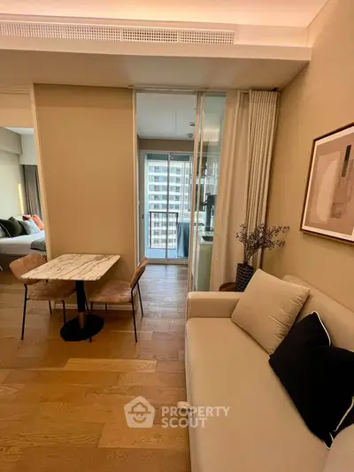 Modern living room with cozy sofa and dining area, featuring elegant decor and wooden flooring.