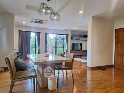 Spacious open-plan living and dining area with modern decor and large windows.