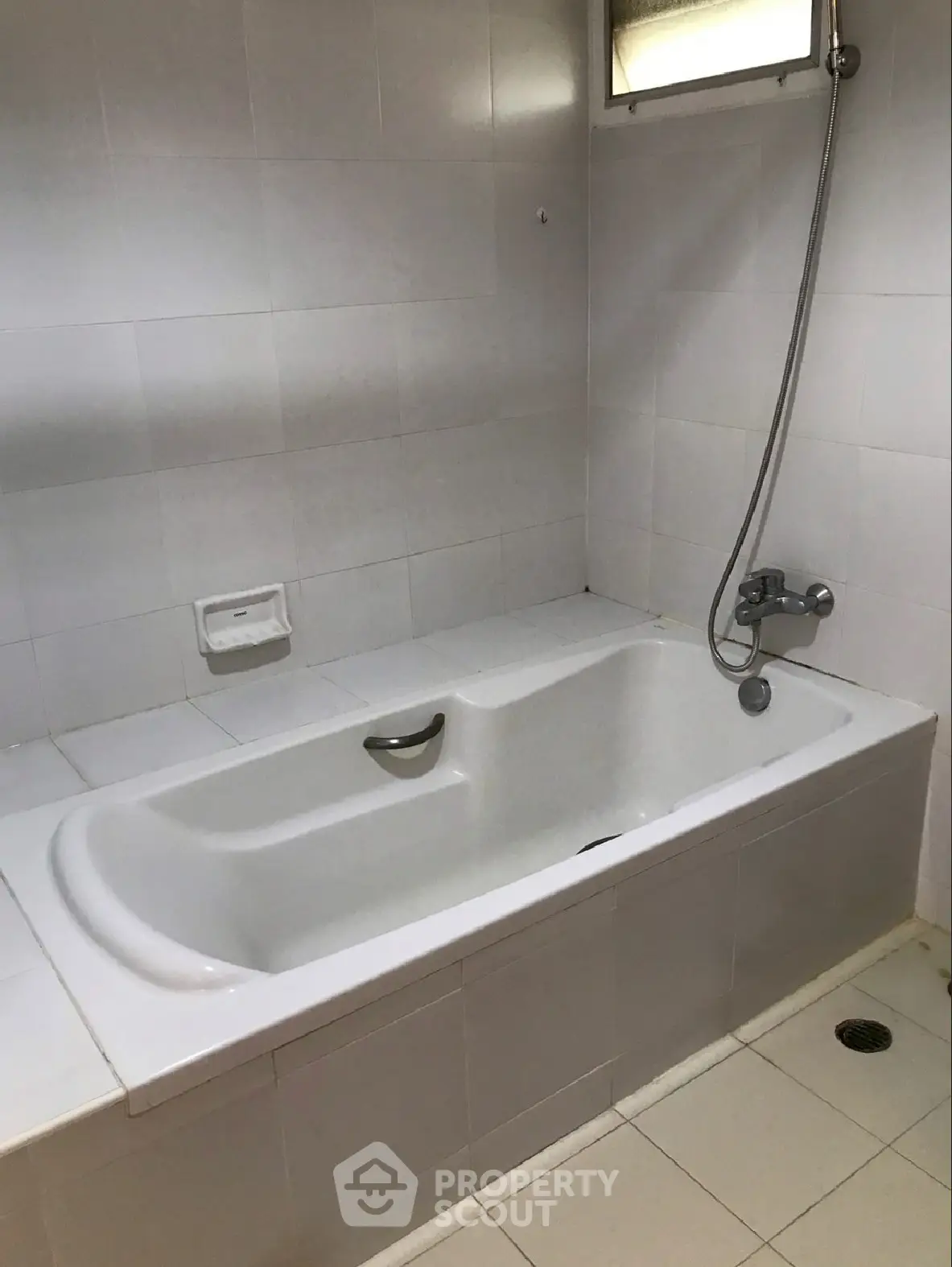 Spacious bathroom with modern bathtub and shower fixture