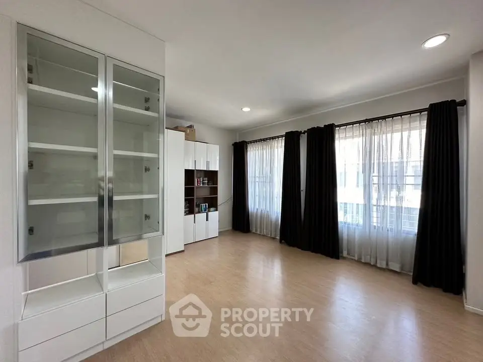 Spacious living room with large windows and elegant curtains