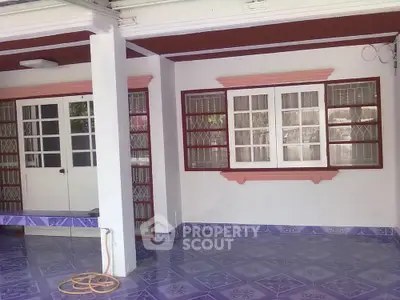 Spacious and airy covered balcony area with vibrant blue tiles and classic white and red accents, perfect for outdoor relaxation or entertaining guests.