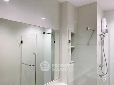 Modern bathroom with glass shower enclosure and sleek fixtures.