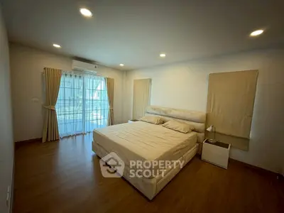 Spacious bedroom with large windows and elegant decor