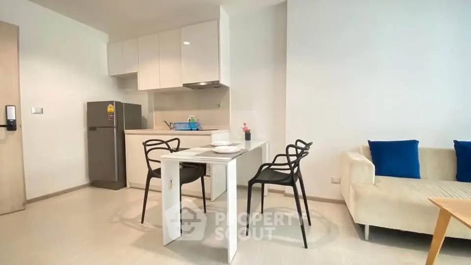 Modern open-layout kitchen and dining area with sleek furniture and cozy seating.