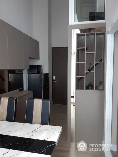 Modern kitchen with sleek cabinetry and marble dining table in stylish apartment