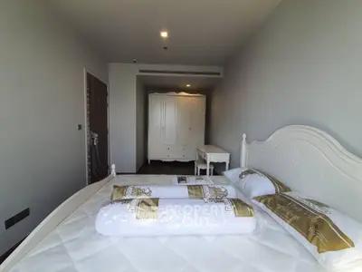 Spacious bedroom with elegant white furniture and cozy bedding in modern apartment.