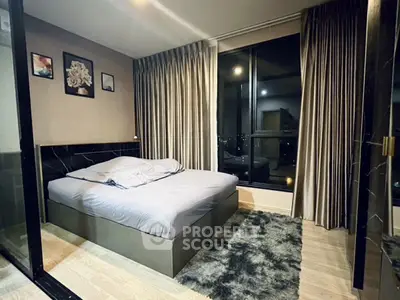 Luxurious bedroom with modern decor and large window offering city views.