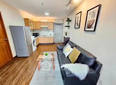 Spacious living room with modern kitchen, cozy seating, and stylish decor in an open-concept apartment.
