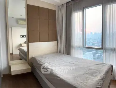 Modern bedroom with large window offering stunning city view