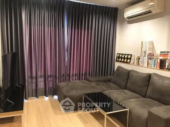 Cozy living room with modern sofa and air conditioning, perfect for relaxation.