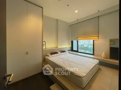 Modern bedroom with large window and built-in storage in urban apartment