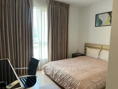 Modern bedroom with stylish decor and natural light, featuring a comfortable bed and sleek furniture.