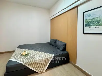Cozy bedroom with minimalist decor and Van Gogh artwork, perfect for relaxation.