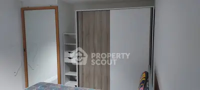Cozy bedroom with modern wardrobe and mirror, perfect for comfortable living.