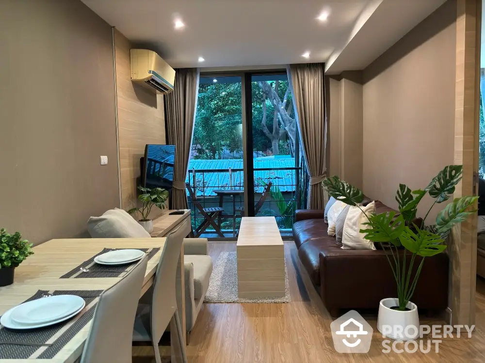 Modern living room with elegant decor and garden view, featuring cozy seating and dining area.