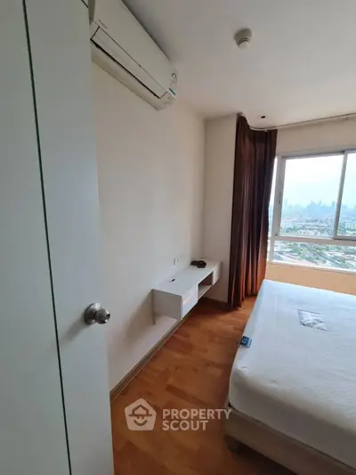 Modern bedroom with city view, featuring air conditioning and wooden flooring, perfect for urban living.