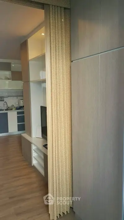 Modern apartment interior with stylish wooden partition and sleek kitchen design.