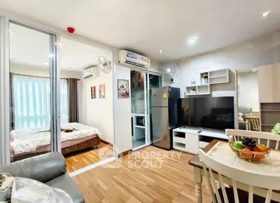Modern open-plan living room with kitchen and bedroom, featuring wooden flooring and stylish decor.