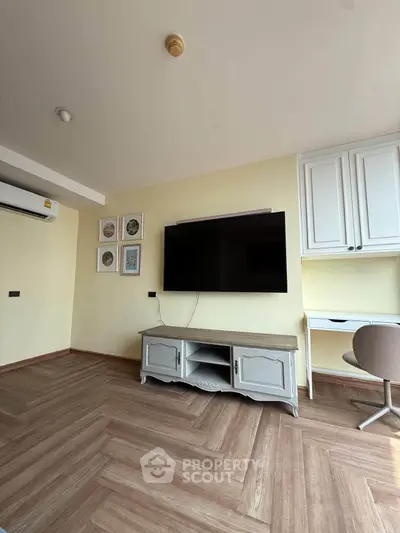 Modern living room with stylish herringbone flooring and wall-mounted TV, perfect for cozy entertainment.