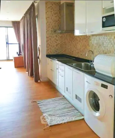 Modern kitchen with washing machine and open layout in bright apartment