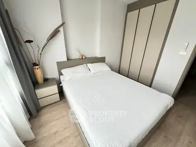 Modern minimalist bedroom with stylish decor and ample natural light.