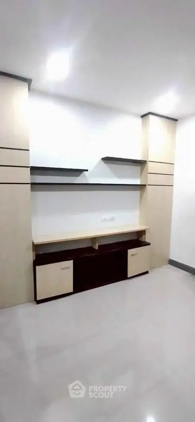Modern minimalist living room with built-in shelving and sleek design.