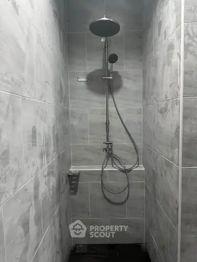 Modern minimalist shower with sleek fixtures in a tiled bathroom