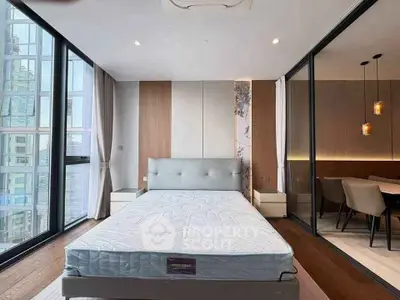 Modern bedroom with large windows and stylish decor in a luxury apartment.