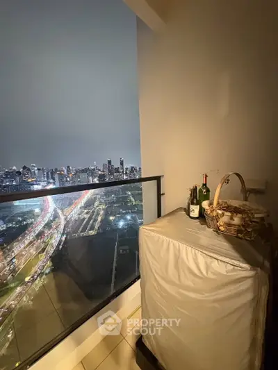 Stunning balcony view of city skyline at night with cozy setup.