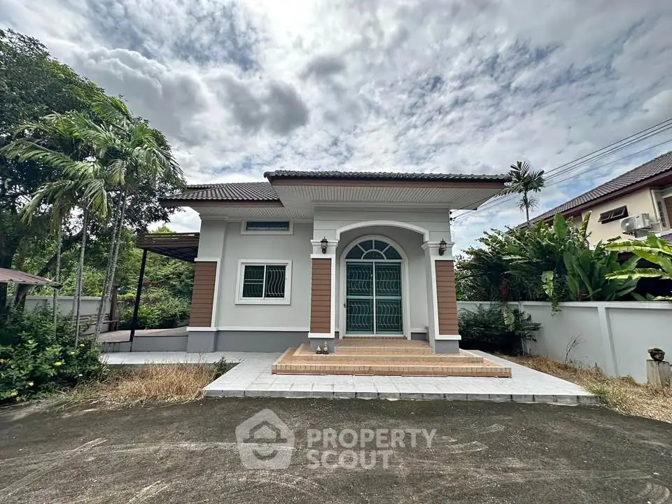 Charming single-story house with lush greenery and elegant entrance, perfect for serene living.