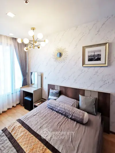 Elegant bedroom with modern decor, featuring a stylish bed, chic lighting, and a cozy vanity area by the window.