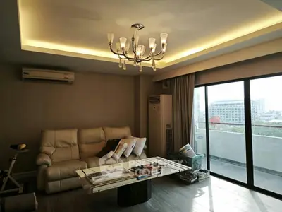 Spacious living room with elegant chandelier and large balcony view