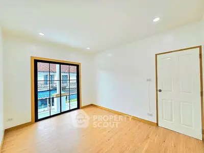Bright empty room with wooden flooring and large window view
