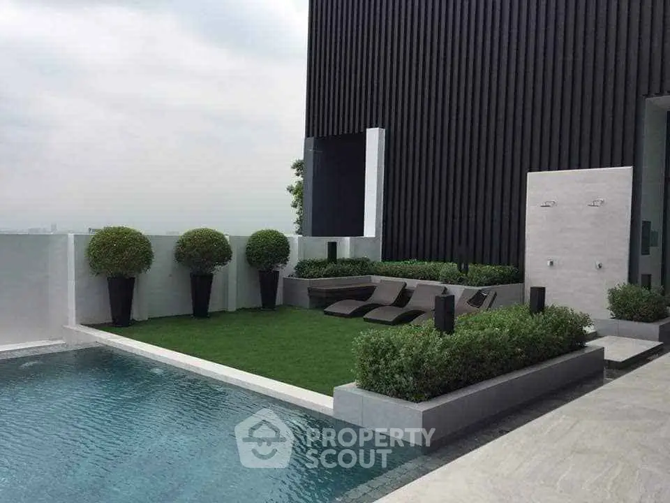 Luxurious rooftop pool with modern design and lush greenery, perfect for relaxation and entertainment.