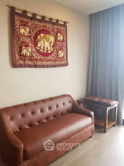 Cozy living room with elegant brown leather sofa and elephant tapestry decor