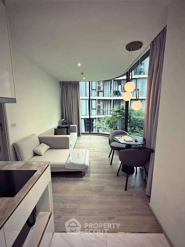 Modern living room with large windows and stylish furniture in a high-rise apartment.