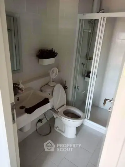 Compact bathroom with shower and modern fixtures in a cozy apartment.