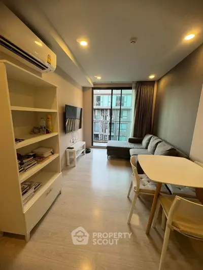 Modern living room with cozy sofa, dining table, and large window offering city view.
