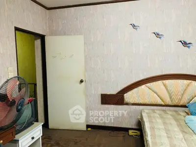 Cozy bedroom with unique wall decor and vintage fan