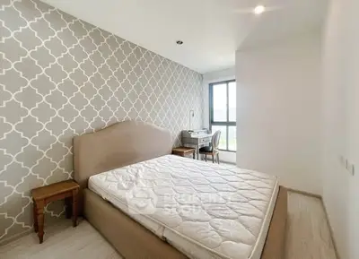 Spacious bedroom with stylish wallpaper and natural light